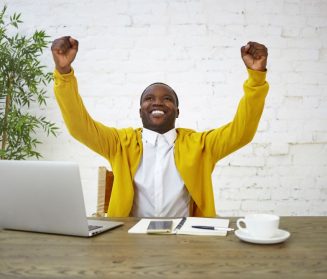 happy-ecstatic-young-fashionable-dark-skinned-businessman-smiling-excitedly-raising-clenched-fists-being-overjoyed-celebrating-successful-meeting-negotiations-good-deal-contract-victory